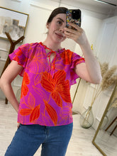 Cargar imagen en el visor de la galería, NIOBE – Blusa fucsia con flores naranjas y mangas de olán