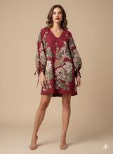 Cargar imagen en el visor de la galería, Vestido Morena: Un diseño de silueta fluida en un profundo tono burdeos, que cautiva con su exuberante estampado floral de estilo tapiz, mangas abullonadas con lazada en los puños y un elegante escote en "V".