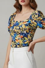 Cargar imagen en el visor de la galería, ESTELA - blusa floral en tonos amarillo y azul con escote cuadrado y mangas abullonadas.