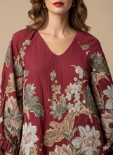 Cargar imagen en el visor de la galería, Vestido Morena: Un diseño de silueta fluida en un profundo tono burdeos, que cautiva con su exuberante estampado floral de estilo tapiz, mangas abullonadas con lazada en los puños y un elegante escote en "V".