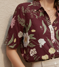Cargar imagen en el visor de la galería, Delia ✨
Blusa de manga corta con estampado floral sobre fondo vino, cuello camisero y botonadura frontal que crea un look femenino, sofisticado y fácil de llevar del día a la noche.